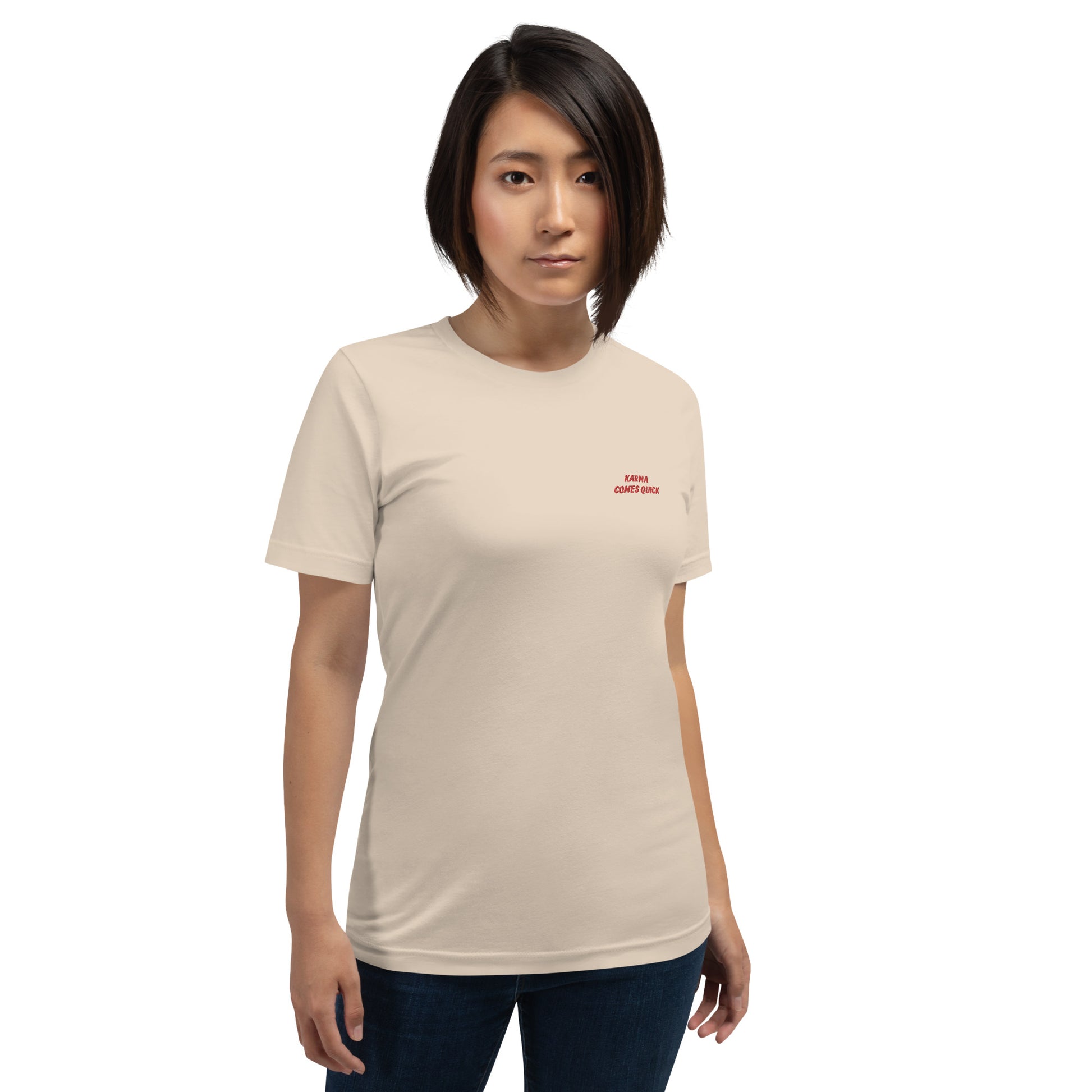 Woman wearing NOMADA Karma Comes Quick embroidered t-shirt, Soft cream color shirt