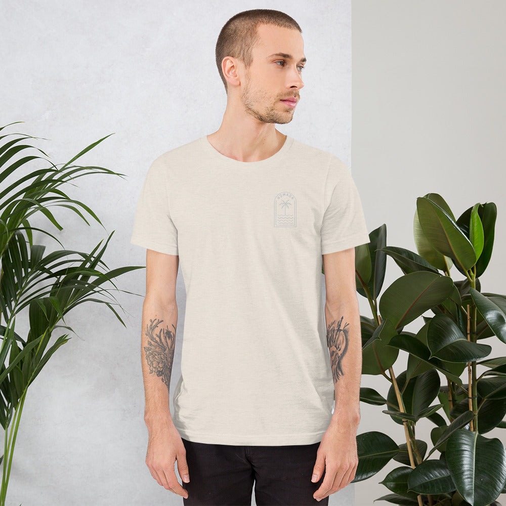 Man wearing NOMADA Palm Tree Lines embroidered T-Shirt, Heather Dust color shirt